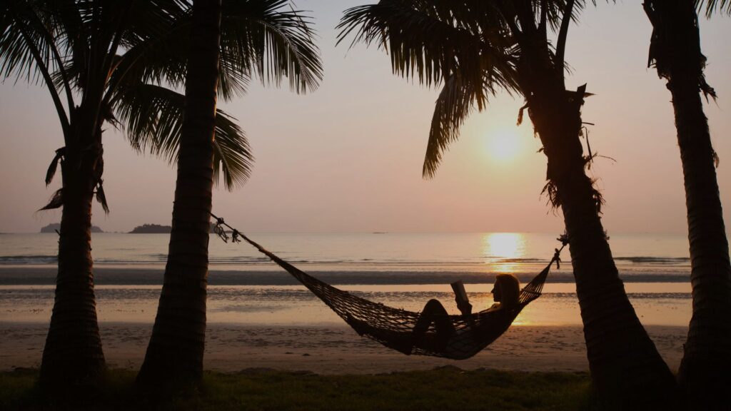 A person in a hammock on a beach